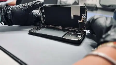 NomoPhone technician opening an iPhone on the workshop bench